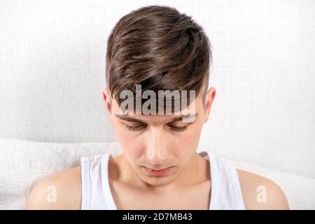 Triste jeune homme à la maison près du mur Banque D'Images