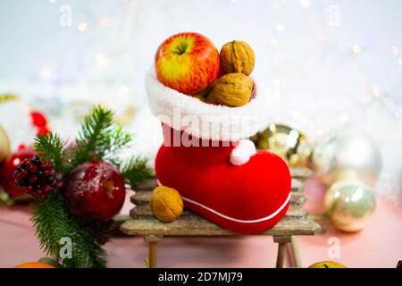 Bottes de père Noël remplies de noix et de pommes, décoration Banque D'Images