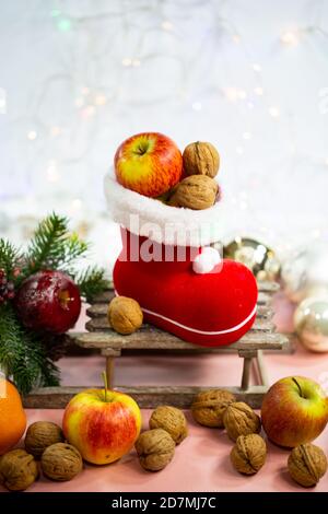 Bottes de père Noël remplies de noix et de pommes, décoration Banque D'Images