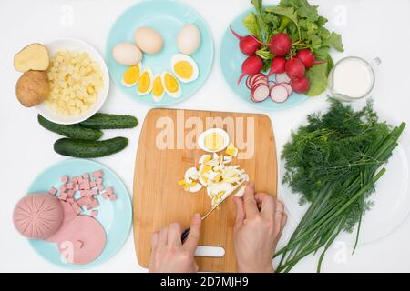 Recette étape par étape pour la soupe russe froide d'okroshka, ingrédients pour la saucisse d'okroshka maison, légumes verts, œufs, concombres, pommes de terre, radis Banque D'Images