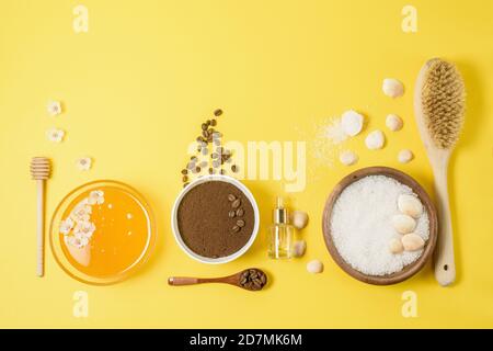 ingrédients naturels biologiques : sel de mer, gommage au café, miel et brosse dure sur fond jaune. soin de la peau à la maison pour la cellulite. concept de peau Banque D'Images