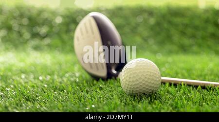 Balle de golf et club sur pelouse, reflets de soleil, vue rapprochée. Concept d'équipement et d'équipement de sport de golf. Banque D'Images