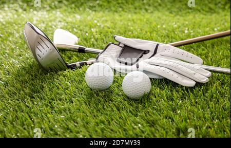 Équipement de golf, bâtons, gants et balles d'or sur la pelouse du parcours vert, vue rapprochée, bannière. Sport de golf et concept de club Banque D'Images