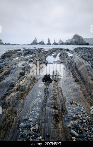 Plan vertical de la côte rocheuse des Asturies pendant une journée nuageux. Vue de la plage de Gueirua. Banque D'Images