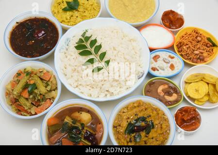 Onam sadhya, femmes indiennes mangeant avec du riz bouilli à la main, servi pour le festival indien du Kerala avec des curries Sambar, Avial, Thoran, Papadum, Payasam, Banana Banque D'Images