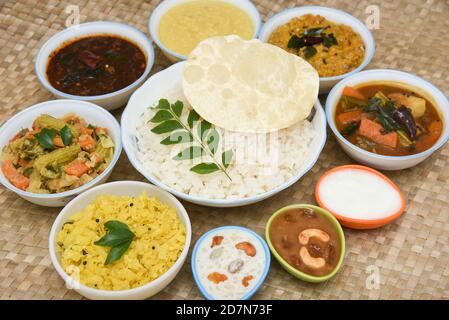 Onam sadhya, femmes indiennes mangeant avec du riz bouilli à la main, servi pour le festival indien du Kerala avec des curries Sambar, Avial, Thoran, Papadum, Payasam, Banana Banque D'Images