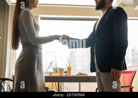 Vue latérale de deux jeunes collègues en vêtements décontractés fenêtre Banque D'Images