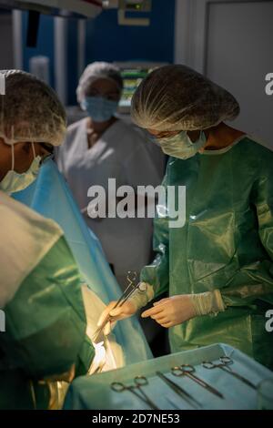 Les chirurgiens contemporains font opération contre leur assistant dans la salle d'opération Banque D'Images