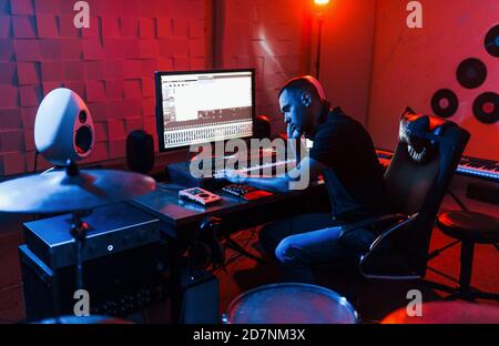 Ingénieur du son travaillant et mélangeant de la musique en intérieur dans le studio près du kit de tambour Banque D'Images