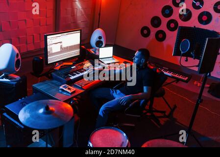 Ingénieur du son travaillant et mélangeant de la musique en intérieur dans le studio près du kit de tambour Banque D'Images
