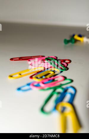 Punaises et trombones de différentes couleurs isolés sur fond blanc. Banque D'Images