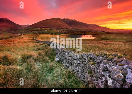 Ciel rose et rouge au lever du soleil, au-dessus des montagnes du Lake District. Tewet Tarn, Keswick, Royaume-Uni. Banque D'Images