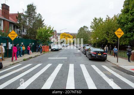 Brooklyn, NY - 24 octobre 2020. Une ligne de personnes désireuses de voter s'est étirée sur 1 km (0.6 mi) une demi-heure après l'ouverture des sondages le premier jour de vote par anticipation à New York. Les portes du bureau de vote de l'université de Brooklyn, dans le quartier de Midwood, ont ouvert aux électeurs à 10 h 00, et un employé du bureau de scrutin a signalé que la première personne à arriver aux portes à 4 h 30 ce matin. Une demi-heure après l'ouverture des bureaux de vote, la ligne s'est accrochée autour du bloc, et en haut et en bas de la 24e rue est, à un pâté de maisons de l'avenue Bedford, et a continué jusqu'à l'avenue J, et jusqu'à la 23e rue est. La ligne est 2 Banque D'Images