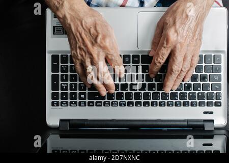 personne âgée travaillant sur un ordinateur portable Banque D'Images