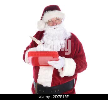 Le Père Noël tient une planchette à pince tenant un stylo aqill faisant des notes sur sa liste méchant et agréable. Isolé sur blanc. Banque D'Images