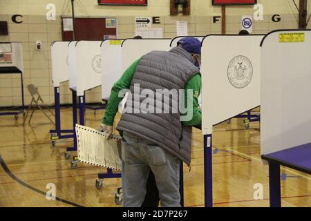 New York, États-Unis. 24 octobre 2020. (NOUVEAU) vote par anticipation à New York. 24 octobre 2020, New York, Etats-Unis: Le vote par anticipation à New York a commencé aujourd'hui le 24 octobre et se déroulera jusqu'au 1er novembre. À la Robert Wagner Middle School, à Manhattan, New York, il y a une longue file de personnes qui attendent longtemps avant l'ouverture du bureau de vote à 10h. La double longue ligne de personnes a commencé à la rue est 75 avec la 3e avenue et va tout autour jusqu'à la 2e avenue et est 76 et de retour au centre de Polling. Les gens se plaignaient du temps d'attente long et certains d'entre eux lisaient des livres, des journaux Banque D'Images