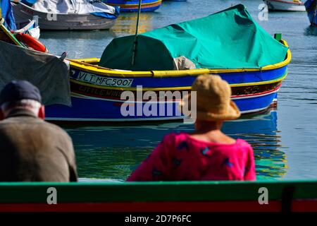 Marsaxlokk, Malte. 24 octobre 2020. Les touristes admirent la beauté du luzzu maltais sur la jetée du village de pêcheurs de Marsaxlokk, Malte, 24 octobre 2020. La ville de Marsaxlokk est célèbre pour le grand nombre de luzzu, un bateau de pêche traditionnel, sur son quai. Credit: Jonathan Borg/Xinhua/Alay Live News Banque D'Images