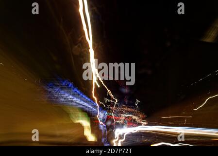 La lumière longue exposition est un arrière-plan urbain abstrait. Différents sentiers de lumière de lanternes de rue multicolores et de voitures de passage diffusion dans le dar Banque D'Images