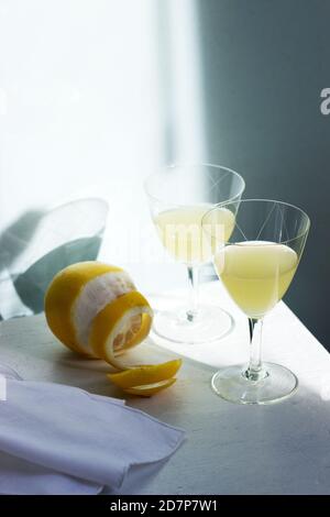 Limoncello italien en verres de cristal et citrons mûrs sur une table en bois. Banque D'Images