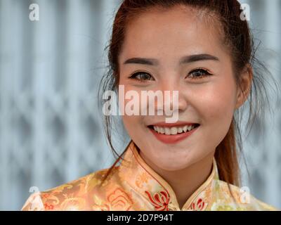 Belle jeune femme thaïlandaise chinoise porte une robe traditionnelle chinoise (cheongsam) et sourit pour la caméra pendant le nouvel an chinois. Banque D'Images