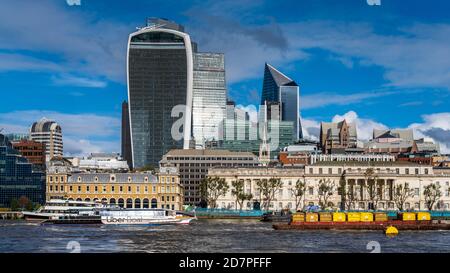 Vue sur la rivière de la ville de Londres - la barge de déchets et le River bus de marque UBER passent devant le bâtiment Walkie Talkie et le quartier financier de la ville de Londres. Banque D'Images