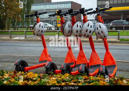 Slough, Berkshire, Royaume-Uni. 24 octobre 2020. 250 e-scooters orange vif et casques de sécurité blancs ont été mis sur 60 sites autour de Slough dans le cadre d'un essai de 12 mois par le conseil de Slough Borough. Les e-trottinettes peuvent être louées à l'aide de l'application Neurone et coûtent 1 £ pour déverrouiller puis 18 pence par minute après cela. Les utilisateurs doivent être 18 ans ou plus et détenir un permis de conduire provisoire ou complet. Ils peuvent être utilisés sur les routes et les voies de bus. Certains sont laissés au milieu des trottoirs, ce qui soulève un problème de risque de trébuchement. Slough est maintenant dans le niveau 2 des restrictions Covid-19 donc certains résidents ont des préoccupations au sujet de Banque D'Images