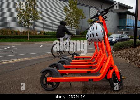 Slough, Berkshire, Royaume-Uni. 24 octobre 2020. 250 e-scooters orange vif et casques de sécurité blancs ont été mis sur 60 sites autour de Slough dans le cadre d'un essai de 12 mois par le conseil de Slough Borough. Les e-trottinettes peuvent être louées à l'aide de l'application Neurone et coûtent 1 £ pour déverrouiller puis 18 pence par minute après cela. Les utilisateurs doivent être 18 ans ou plus et détenir un permis de conduire provisoire ou complet. Ils peuvent être utilisés sur les routes et les voies de bus. Certains sont laissés au milieu des trottoirs, ce qui soulève un problème de risque de trébuchement. Slough est maintenant dans le niveau 2 des restrictions Covid-19 donc certains résidents ont des préoccupations au sujet de Banque D'Images