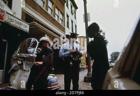 L'officier rédigeant un rapport sur une perturbation régulière de la paix (Washington D.C.) ca. 1973 Banque D'Images