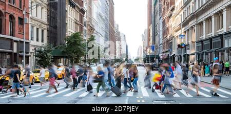 Scène de rue animée dans la ville de New York avec des groupes de Les gens qui marchent à travers une intersection bondée sur la Cinquième Avenue dans Midtown Manhattan, New York Banque D'Images