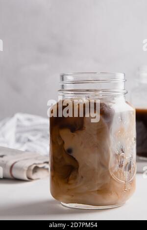 Plan vertical de la préparation d'un latte de lait de café dans un pot Banque D'Images