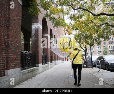 États-Unis. 24 octobre 2020. Une femme marche sur le trottoir portant une balle jaune avec les mots « vote » écrits après le rassemblement « Plus1Vote's March for National Early vote Day » le premier jour du vote par anticipation pour l'élection de 2020 à New York le samedi 24 octobre 2020. Les électeurs de New York pour la première fois ont la possibilité de voter tôt pour l'élection de 2020 et certains ont attendu des heures en ligne avant l'ouverture de leur site de vote à 10 heures. Photo par John Angelillo/UPI crédit: UPI/Alay Live News Banque D'Images