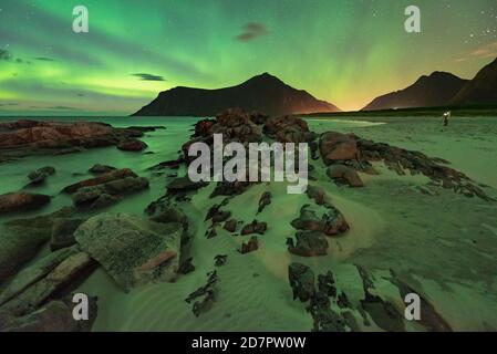 Lumières du nord sur la plage rocheuse, dans le petit photographe arrière avec trépied, Leknes, Nordland, Lofoten, Norvège Banque D'Images