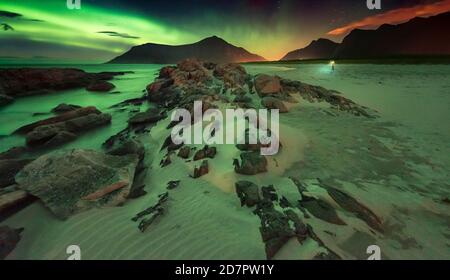 Lumières du nord sur la plage rocheuse, dans le petit photographe arrière avec trépied, Leknes, Nordland, Lofoten, Norvège Banque D'Images