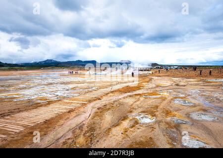 Hverir, Islande - 16 juin 2018 : pots de boue à vapeur à fumeroles chaudes avec parking et les gens touristes au printemps sur le sentier par les geysers dans l'ar géothermique Banque D'Images