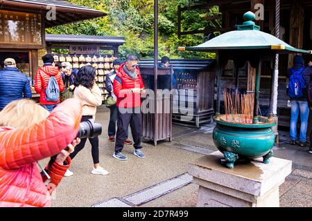 Kyoto, Japon - 10 avril 2019 : Pavillon d'or de Kinkakuji temple bouddhiste Zen de Rokuonji avec de nombreux touristes prenant des photos d'encens Banque D'Images