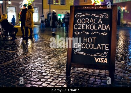 Varsovie, Pologne - 19 décembre 2019 : panneau du café-restaurant pour chocolat chaud avec paiement par carte de visa accepté, les gens boivent sur la place du marché de la vieille ville Banque D'Images