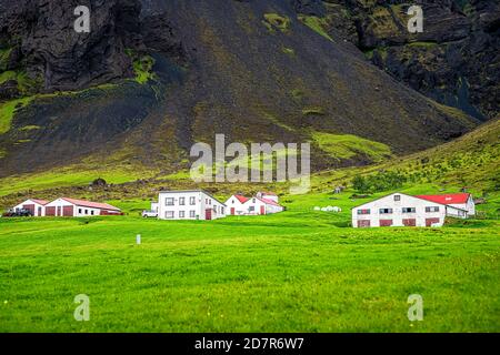 Vue sur le paysage islandais de l'ancienne église en gazon de la ville de Hof petit village en été sur la rocade sud-sud avec herbe verte et maisons de ferme Banque D'Images