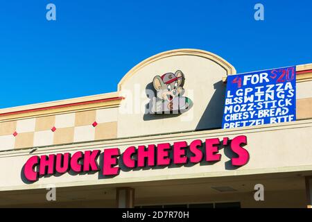 Le logo Chuck E. Cheese et l'affiche publicitaire de la femme de ménage choisissent 4 articles pour 20 dollars au-dessus de l'entrée du centre de divertissement familial et du restaurant - C Banque D'Images