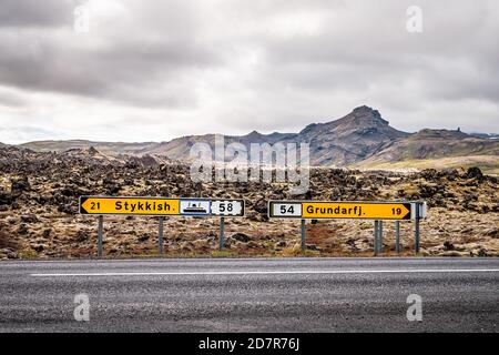 Champ de lave noir sur la péninsule de Snaefellsnes en Islande avec direction Signes pour Stykkish Stykkisholmur et Grundarfjordur avec personne sur vide route Banque D'Images