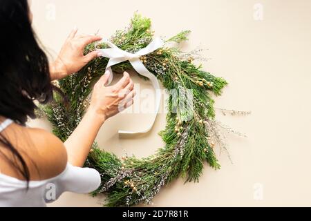 Jolie femme décorera la couronne de l'AVENT avec ses mains Banque D'Images