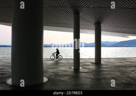 Cycliste longeant le Paseo Maritimo de Santander Cantabria Espagne Le matin ensoleillé d'octobre à l'ombre du Centre artistique Centro Botin Banque D'Images