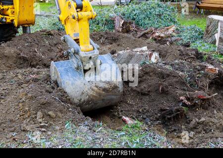 Travaux de chantier bulldozer défrichement de terres de vieux arbres, racines et branches avec des machines de pelle rétro dans le quartier urbain. Banque D'Images