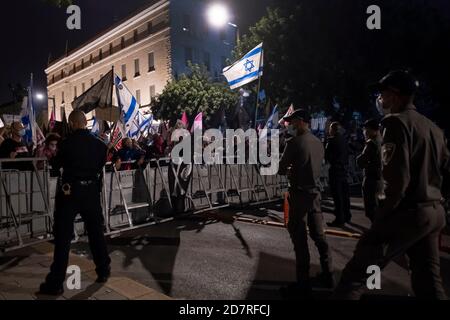 JÉRUSALEM, ISRAËL - 24 OCTOBRE : la police veille à ce que les manifestants tiennent des pancartes et des drapeaux israéliens lors d'une manifestation de masse devant la résidence officielle du Premier ministre le 24 octobre 2020 à Jérusalem, en Israël. Les organisateurs de la manifestation ont déclaré dans une déclaration que 170,000 personnes se sont montrées pour manifester contre le Premier ministre Benjamin de tout le pays exigeant sa démission en raison de son inculpation pour corruption et pour la gestion de la pandémie COVID-19. Banque D'Images