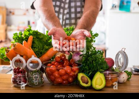 Un mode de vie alimentaire sain avec l'homme et les légumes mélangés et l'avocat sur une table en bois - concept de personnes et cuisine avec des légumes frais de saison de couleur Banque D'Images