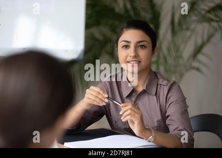 Une jeune femme d'affaires indienne parle avec un partenaire d'affaires au bureau Banque D'Images
