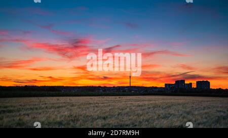 Allemagne, Stuttgart, magnifique coucher de soleil rouge au-dessus des champs et tour de télévision Fernsehturm en été à l'heure bleue Banque D'Images