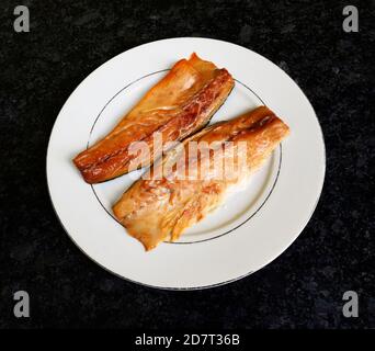 Deux filets de maquereau fumé sur une assiette blanche. Banque D'Images