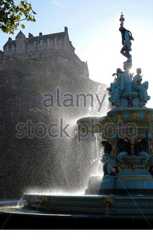 Édimbourg, Écosse, Royaume-Uni. 25 octobre 2020. Vents violents créant beaucoup de jets sur la fontaine Ross, normalement tranquille, des jardins de West Princes Street, les piétons prenant soin de ne pas se mouiller. Le soleil rétro-éclairé et filtrant à travers le spray, avec une vue sur le château d'Édimbourg. Crédit : Craig Brown/Alay Live News Banque D'Images