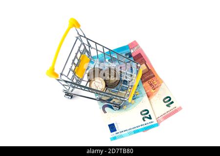 Petit panier rempli de pièces et d'argent en euros. Quatre pièces dans un chariot jaune sur fond de trente euros. Concept de dépense et de shopping. Isolé. Banque D'Images