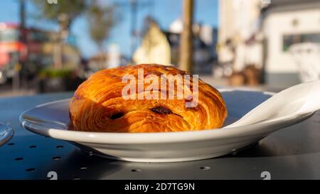 Pain au chocolat sur une assiette à l'extérieur café de rue Banque D'Images